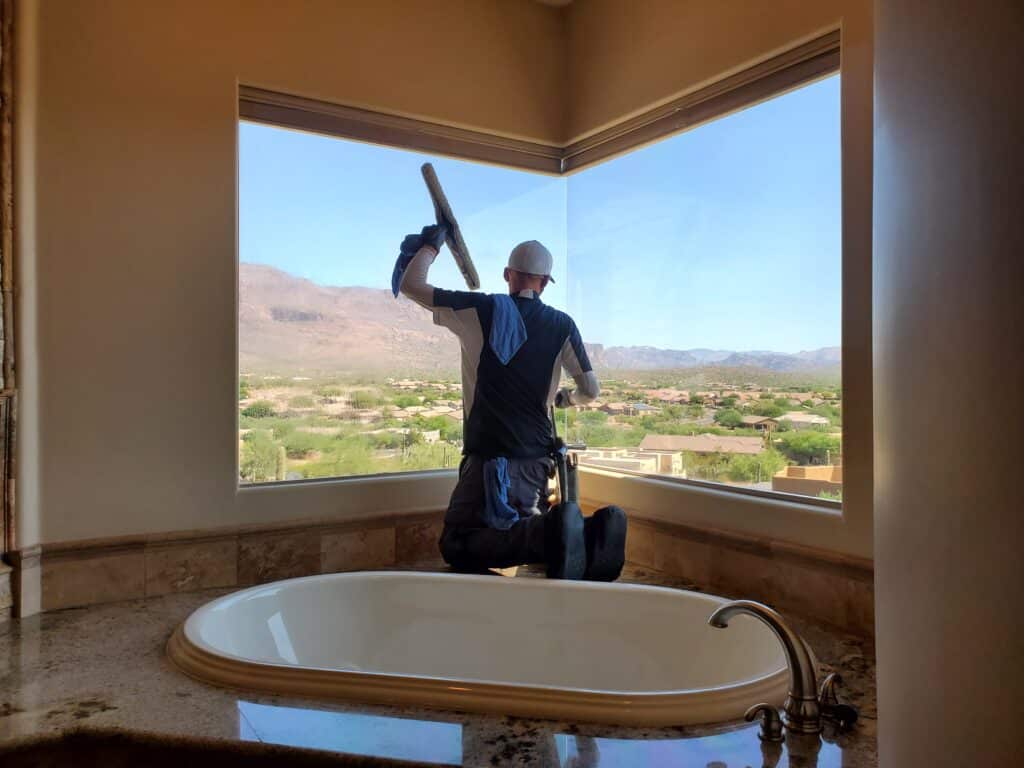 Image of a Ace Window Cleaning Pro cleaning interior windows in a home.